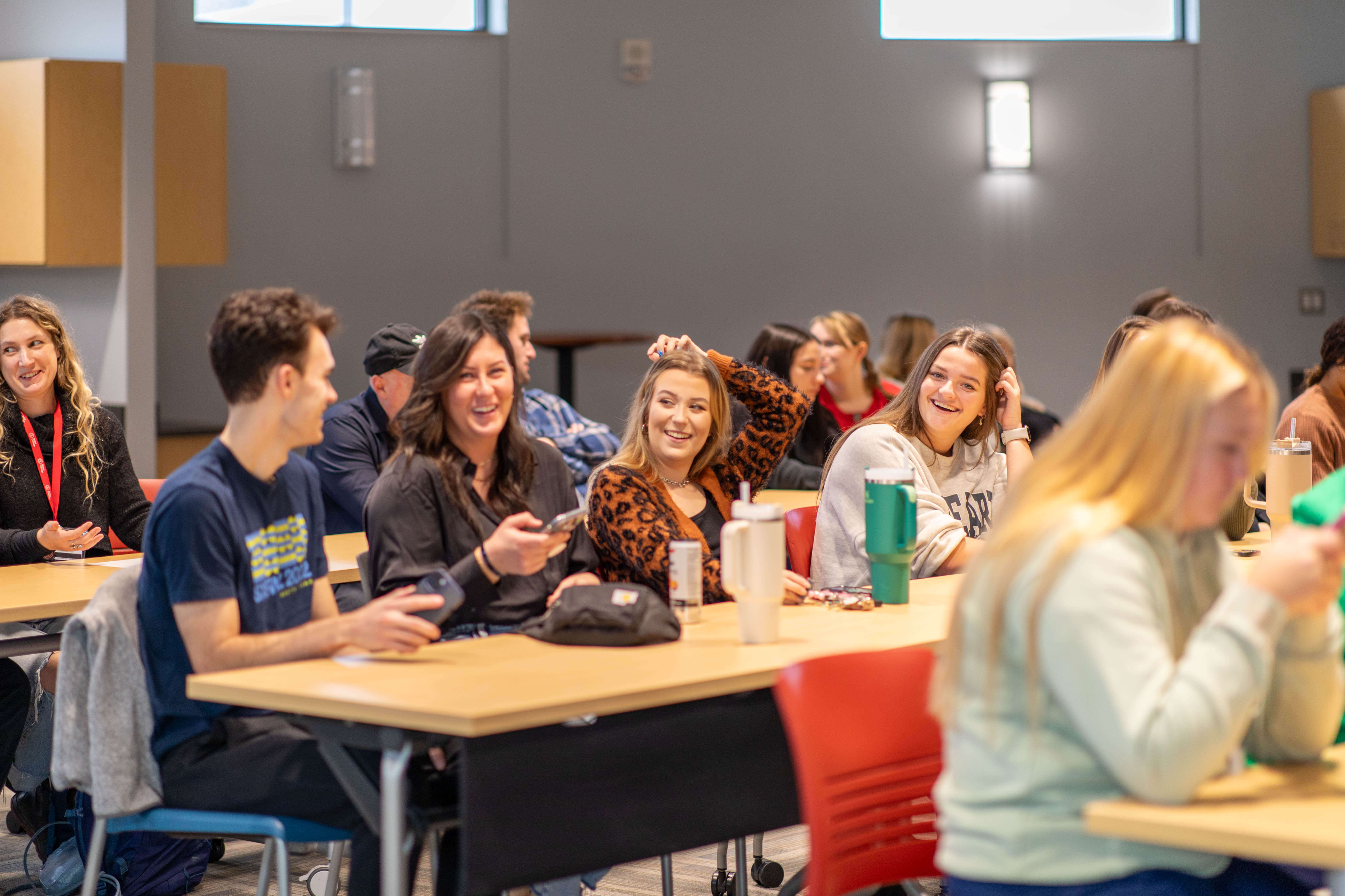 Group of students in a classroom talking and laughing