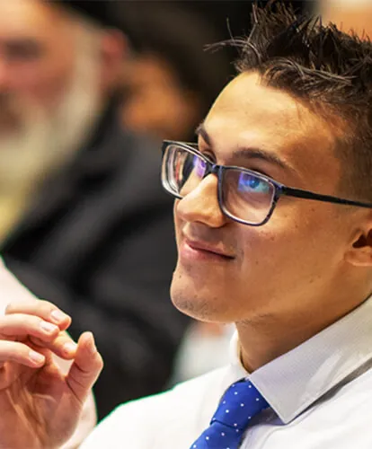 A student listens intently in a crowd.