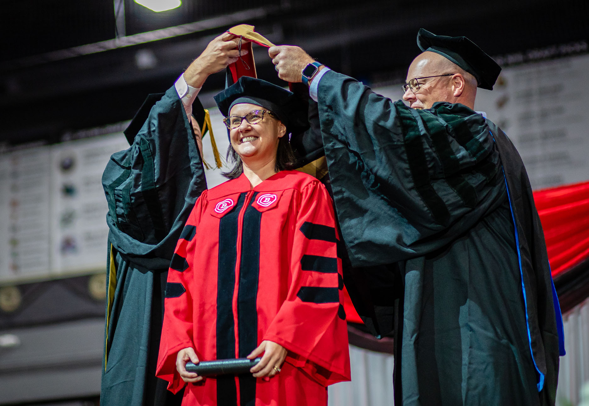 Baker College doctoral student graduate being hooded at commencement.