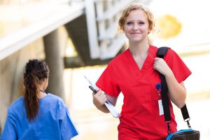 Nurse with clipboard and computer case.