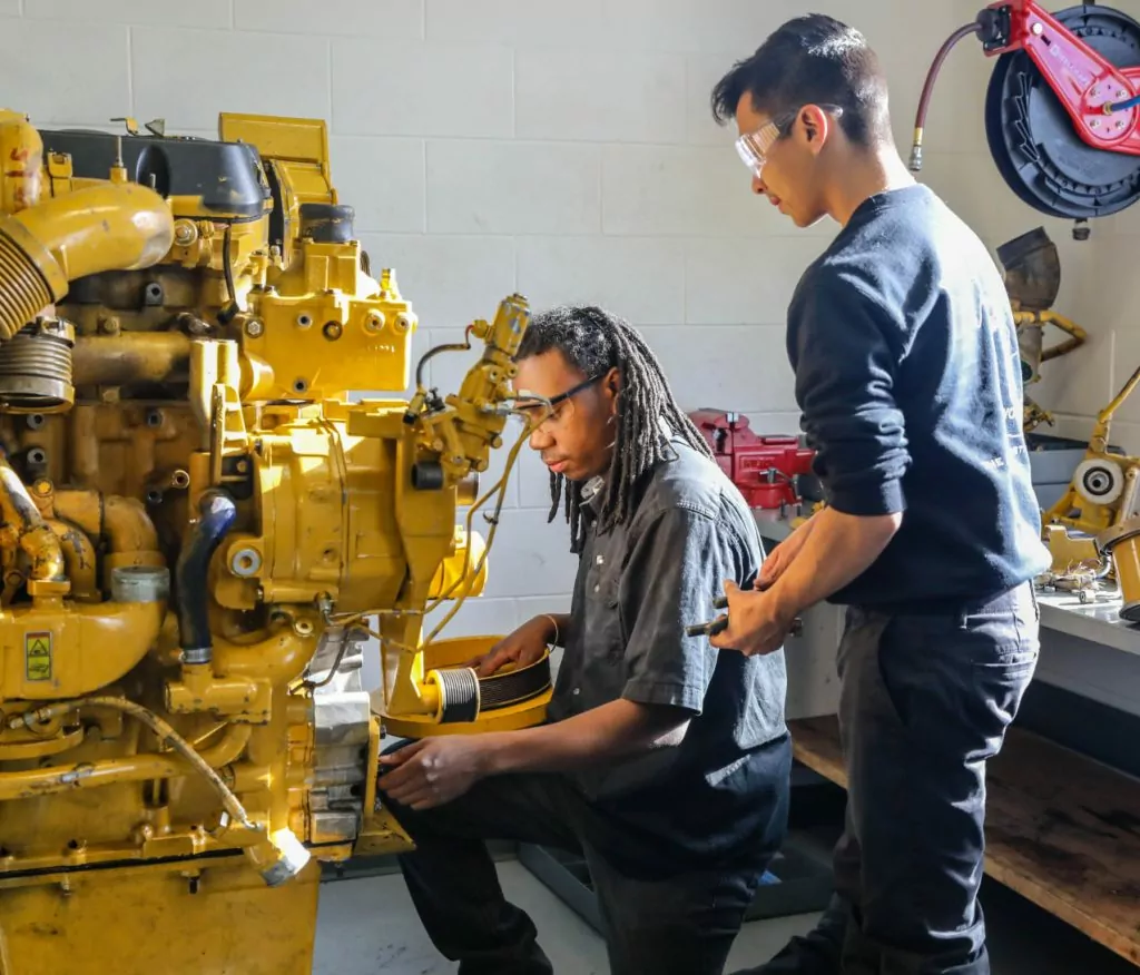 two students working on an engine