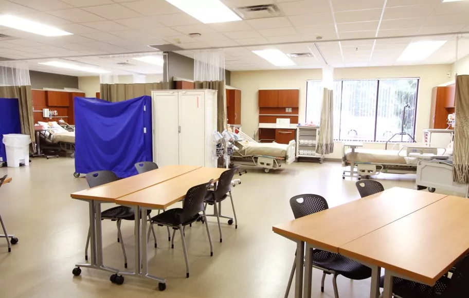 Classroom at the Jackson campus with hospital beds, tables and chairs..