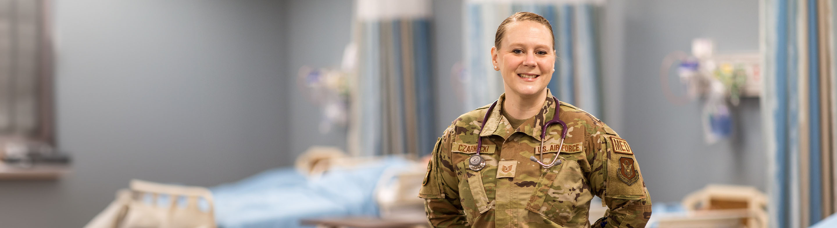 Militray student in camo stands in a nursing lab