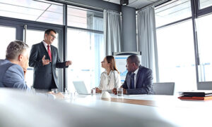 A group of business people discuss at a conference table.