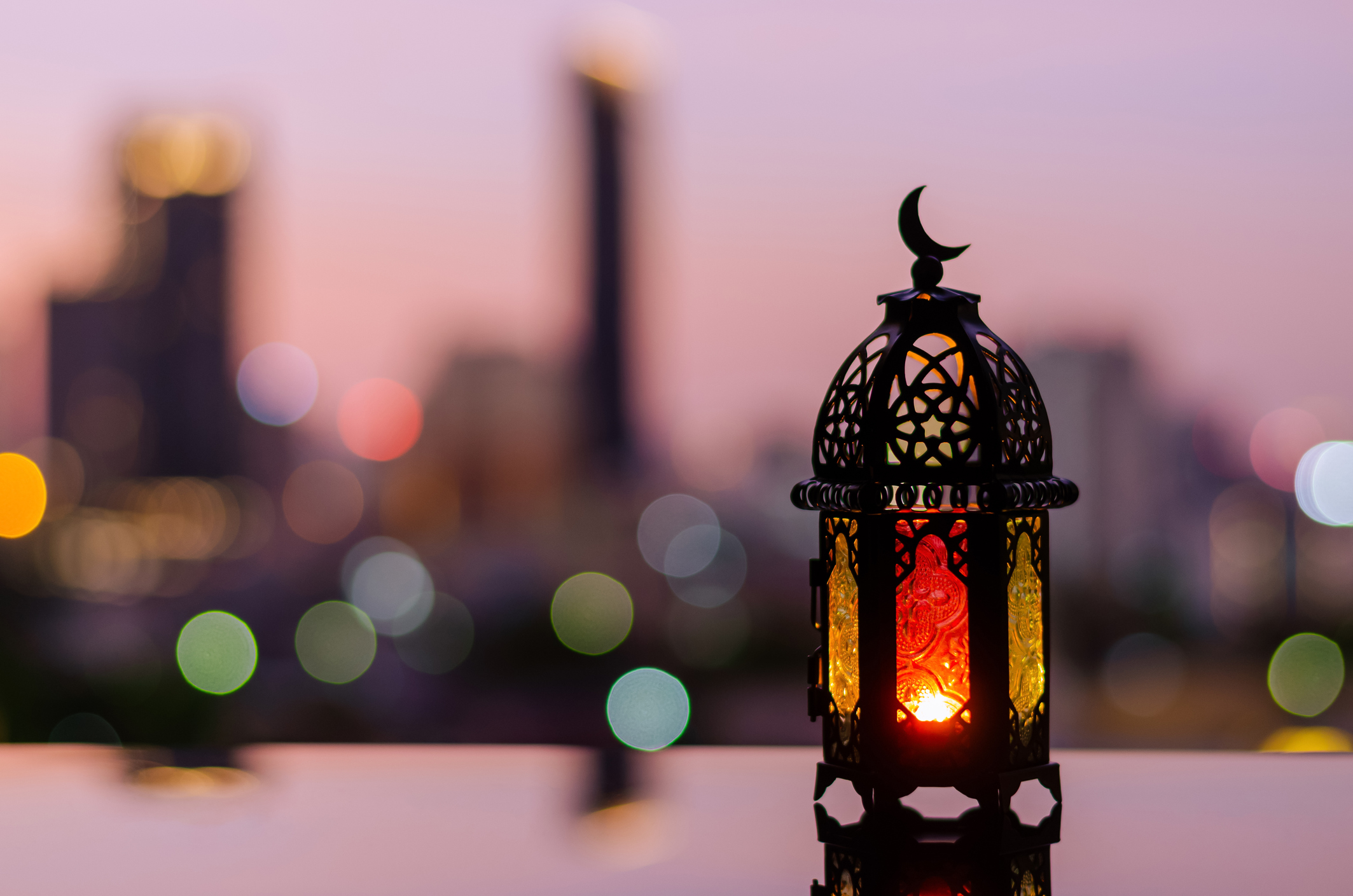 Lantern with dusk sky and city bokeh light background for the Muslim feast of the holy month of Ramadan