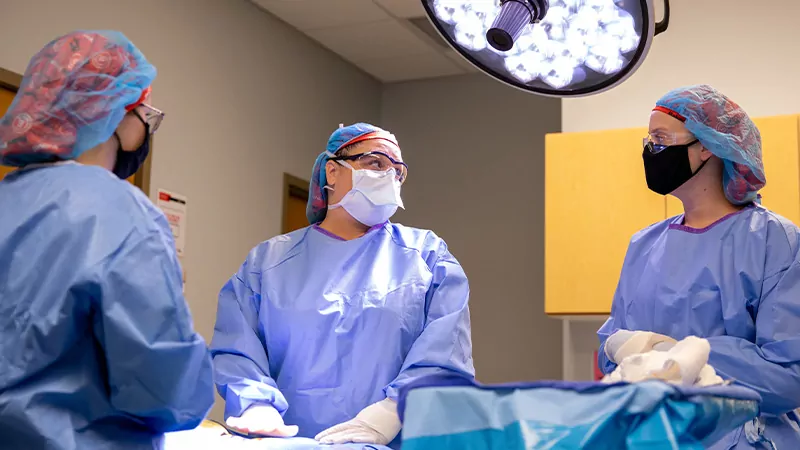 Surgical technology instructor and two students stage a surgery procedure.