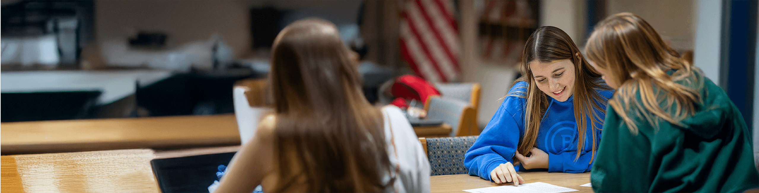 Three students study together on campus.