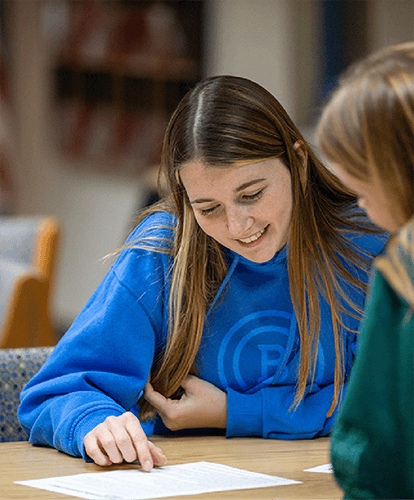 Two students study together on campus.