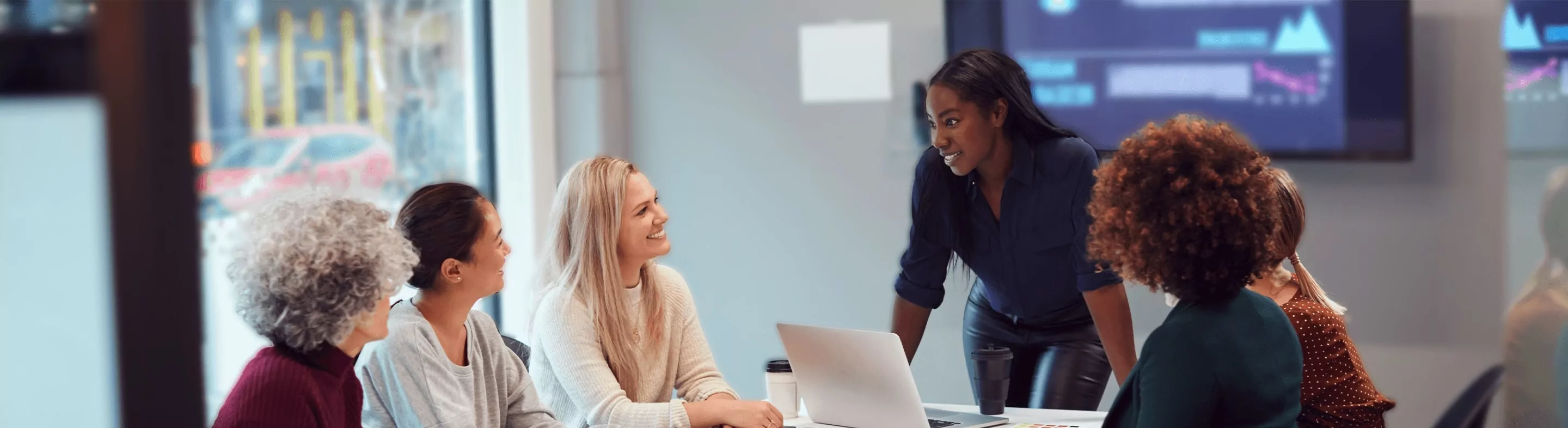 Business woman speaking to peers over a table