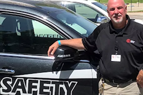 Campus safety officer standing next to Campus Safety SUV.