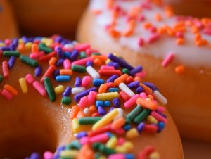 A close-up of two donuts with colorful sprinkles.