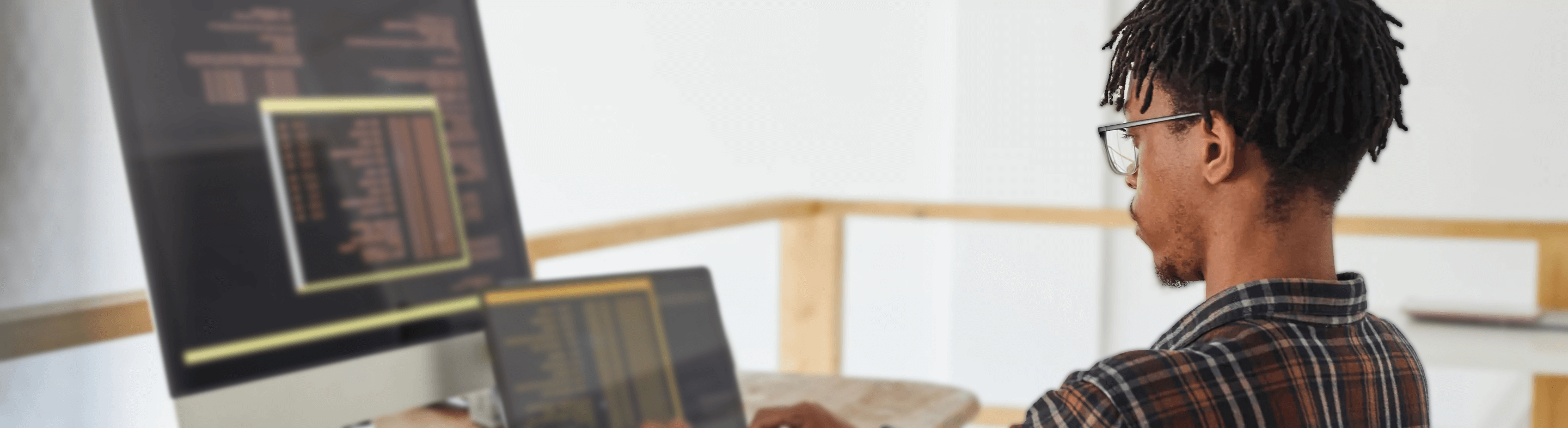 Man faces two computers with technical information on the screens