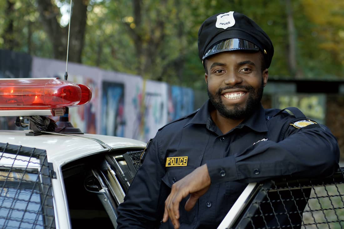 Happy and smiling African American police officer looking at the camera.