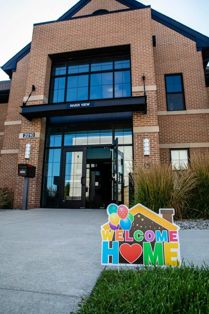 A colorful Welcome Home sign outside of Baker College student housing.