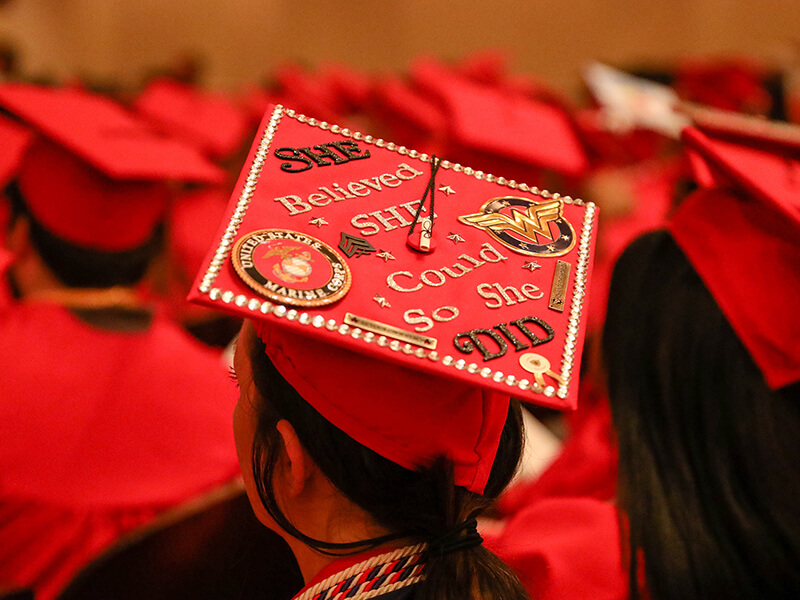 A decorated graduation cap as seen from above that says "She believed she could so she did"