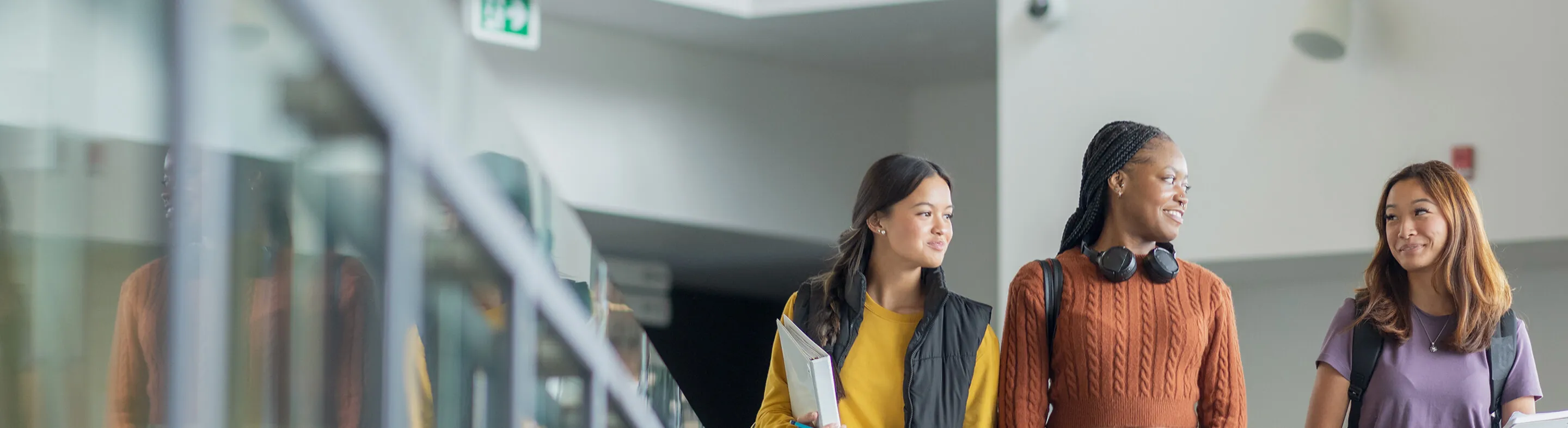A group of students walk down the hallway on campus.