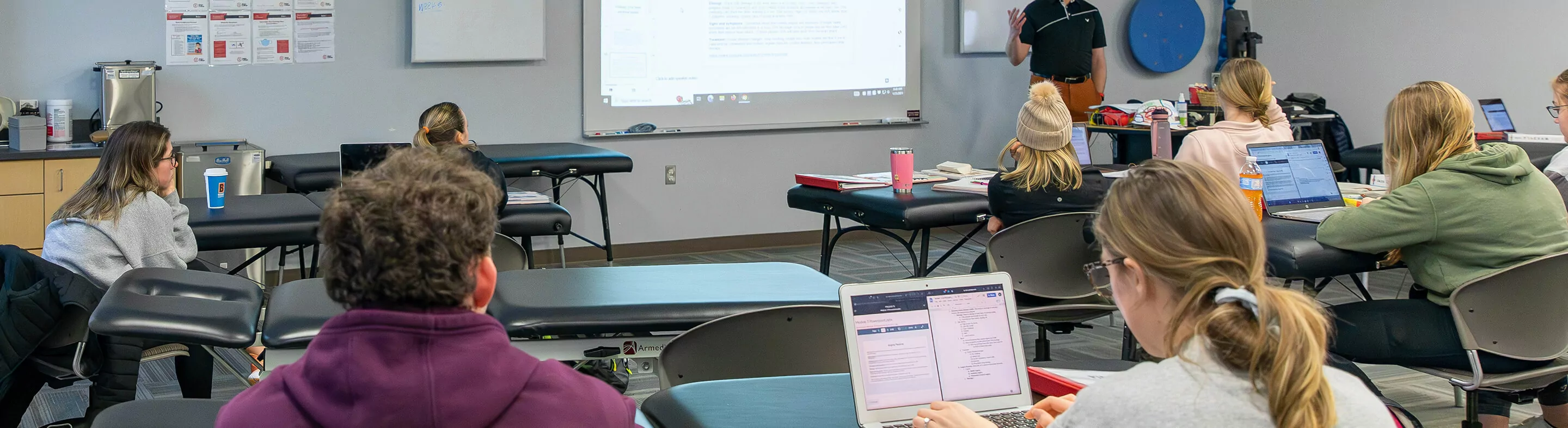 Students listen and take notes in a classroom.