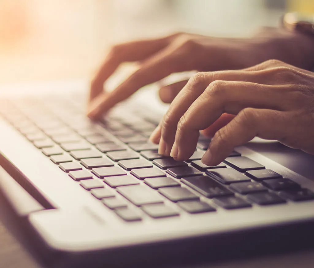 A pair of hands typing on a keyboard.
