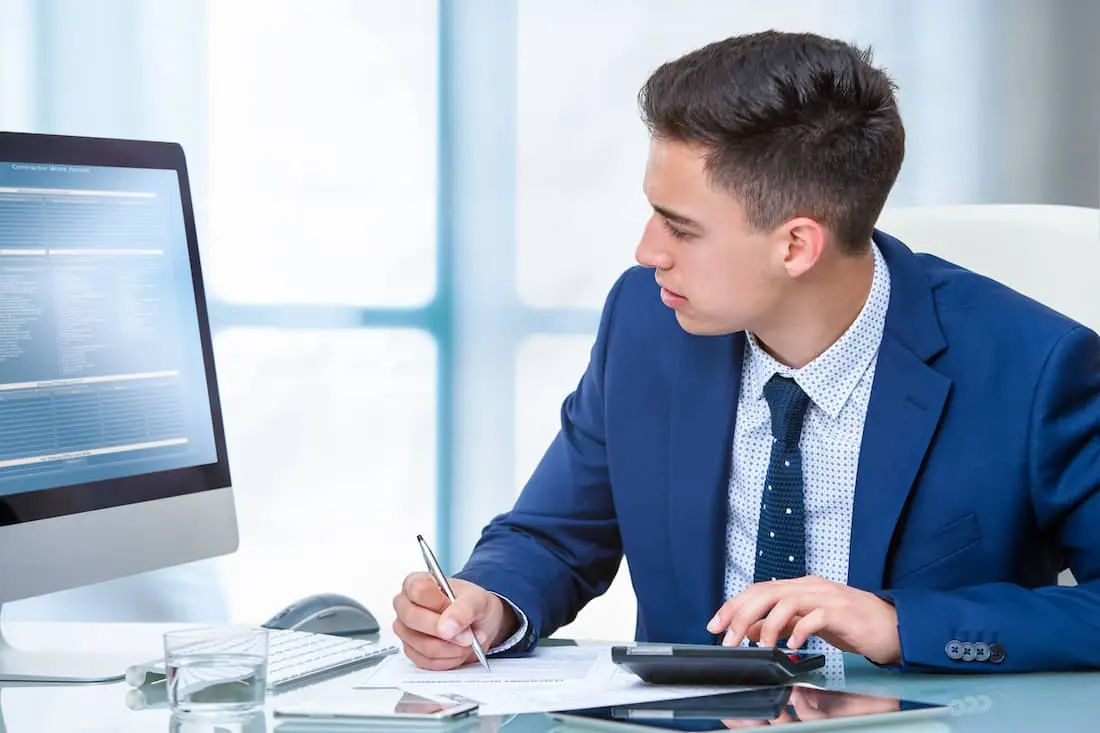 Close up portrait of young accountant doing on line internet transaction.