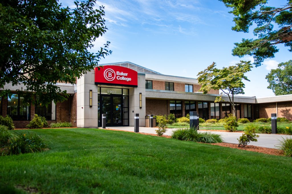 An exterior photo of the Muskegon campus and the red Baker College sign hanging above the door.