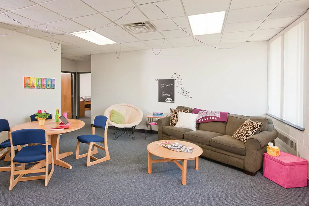 Living room with sofa and coffee table, and a round table with chairs.