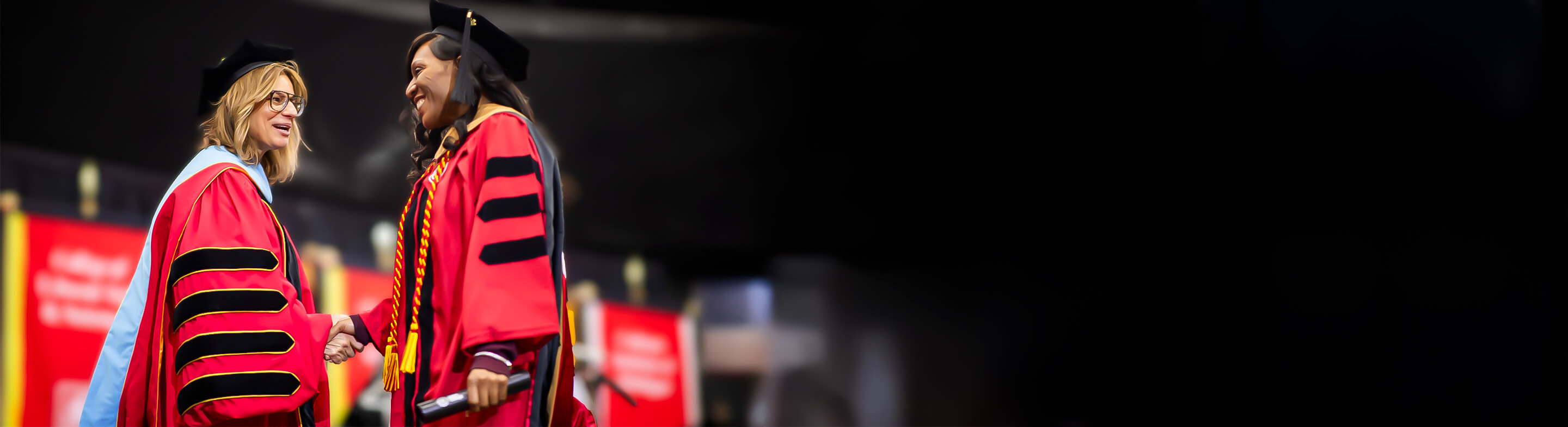 President Spicer shakes hands with a new graduate during the Commencement Ceremony.