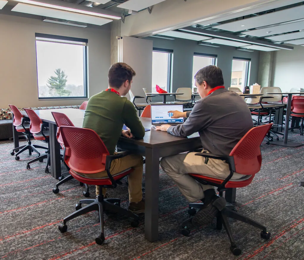 A staff member helps a student apply for financial aid.