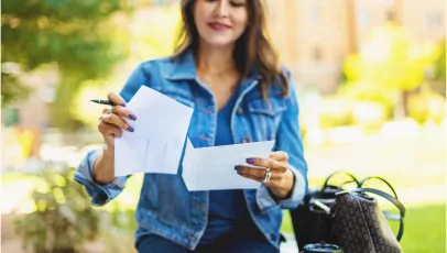 Woman placing paper in an envelope